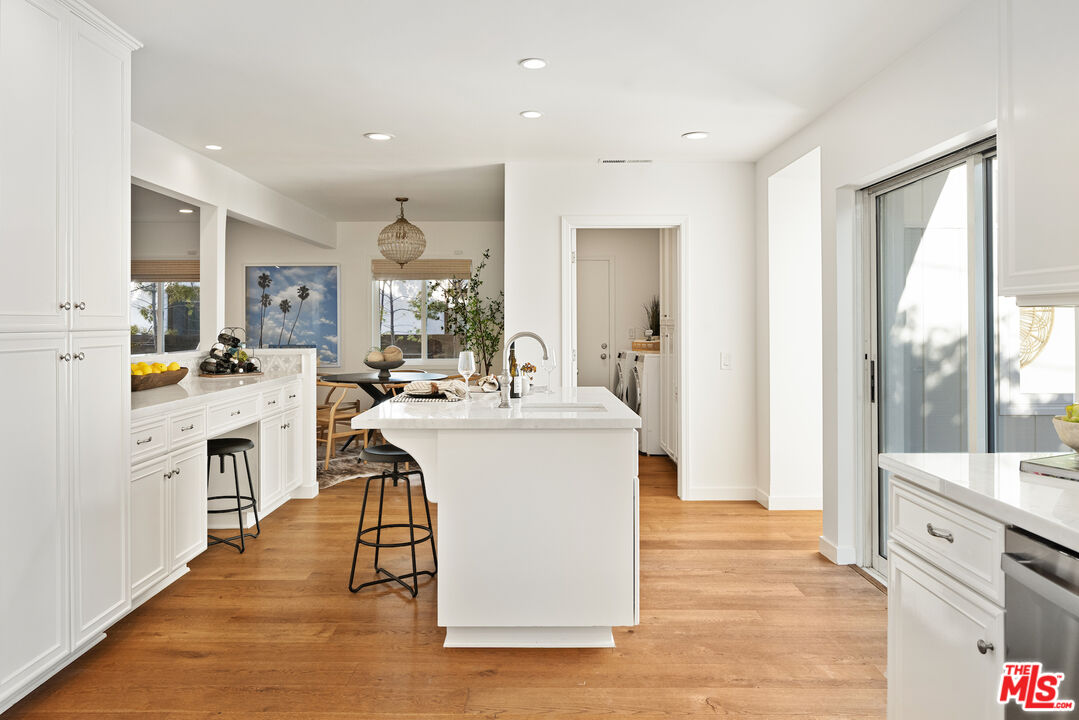 1314 Preston Way Venice, CA 90291 - Photo 17 of 37 a large white kitchen with a stove a sink a refrigerator and a dining table view with wooden floor