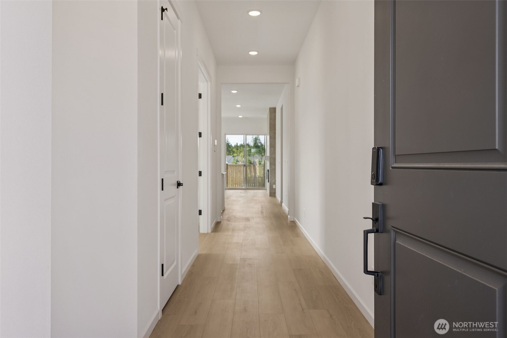 4142 Southwest Muller Lane, Unit 310 Port Orchard, WA 98367 - Photo 2 of 14 a view of a hallway with wooden floor and a bathroom