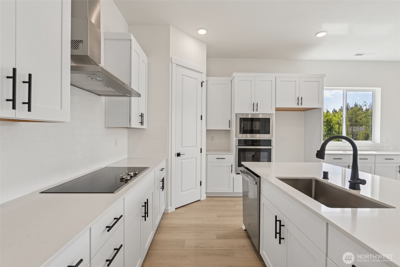 4142 Southwest Muller Lane, Unit 310 Port Orchard, WA 98367 - Photo 6 of 14 a kitchen with kitchen island white cabinets and white appliances