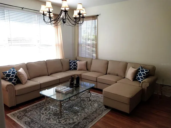 a living room with furniture and a chandelier