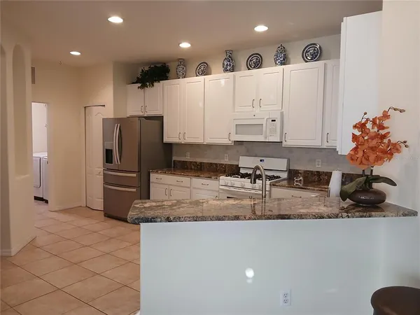 a kitchen with stainless steel appliances granite countertop a refrigerator and a sink