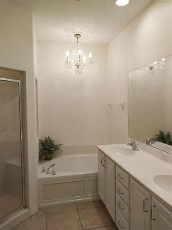 a large bed sitting in a bedroom next to a window with lamp