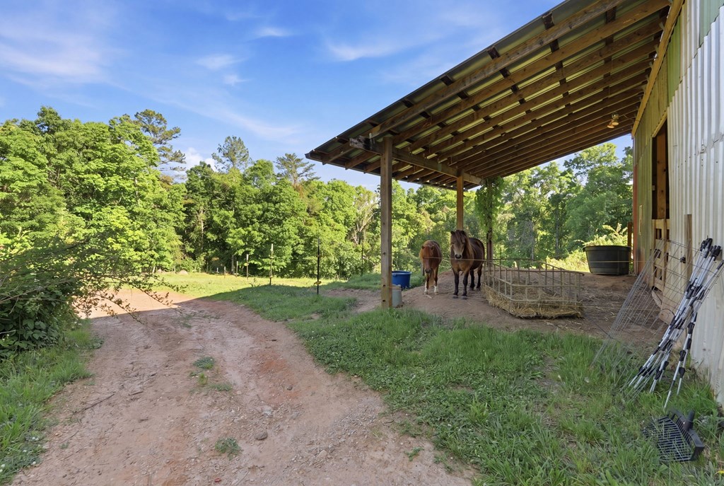 1823 Shoal Creek Road Clarkesville, GA 30523 - Photo 113 of 149 a view of a patio with table and chairs under an umbrella with a barbeque