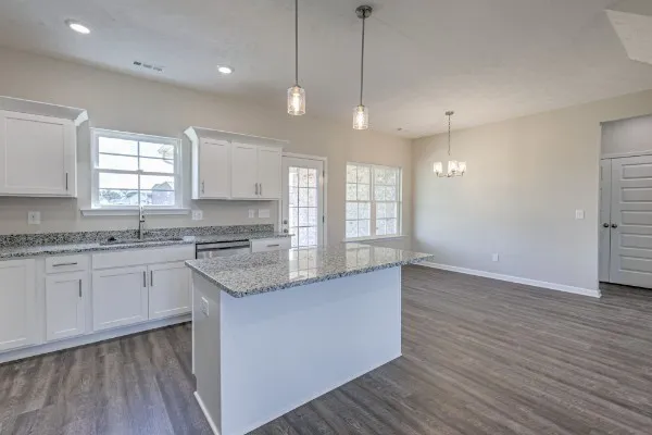 a kitchen with stainless steel appliances granite countertop wooden floors sink and window
