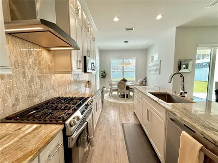 a kitchen with stainless steel appliances granite countertop a stove and a microwave