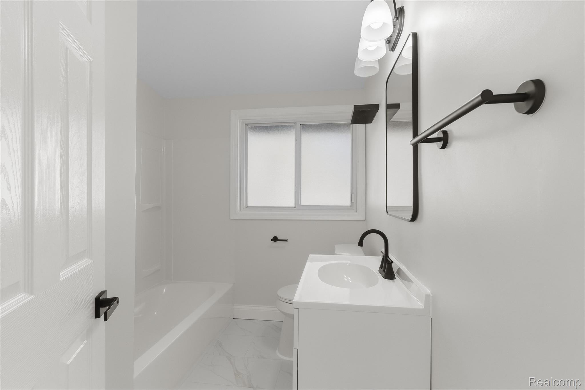 9101 Merriman Road Livonia, MI 48150 - Photo 15 of 41 White vanity with a white countertop, matte black faucet, and rectangular mirror