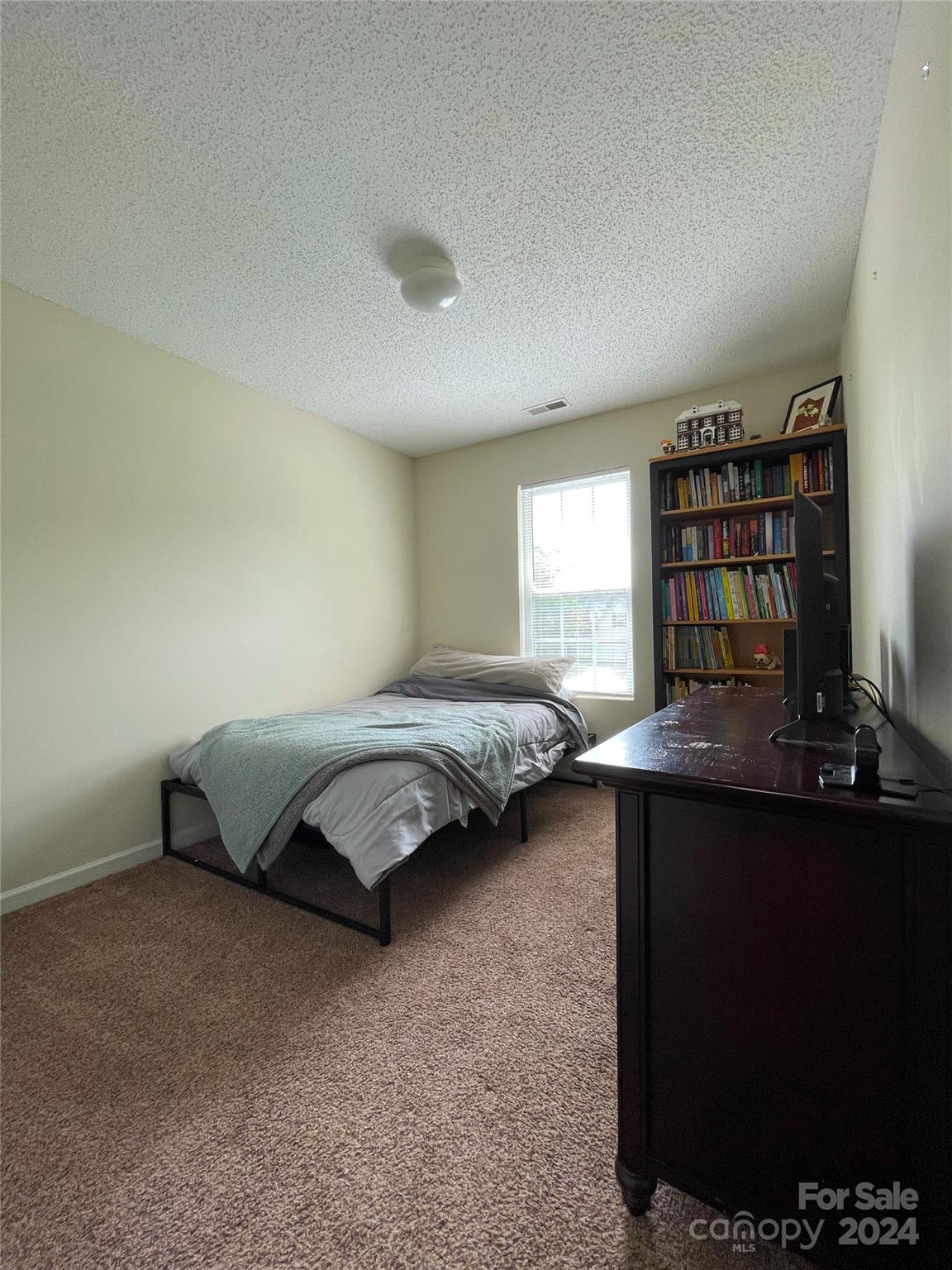 3216 Barons Court Road Charlotte, NC 28213 - Photo 26 of 29 a bedroom with a bed and a bookshelf