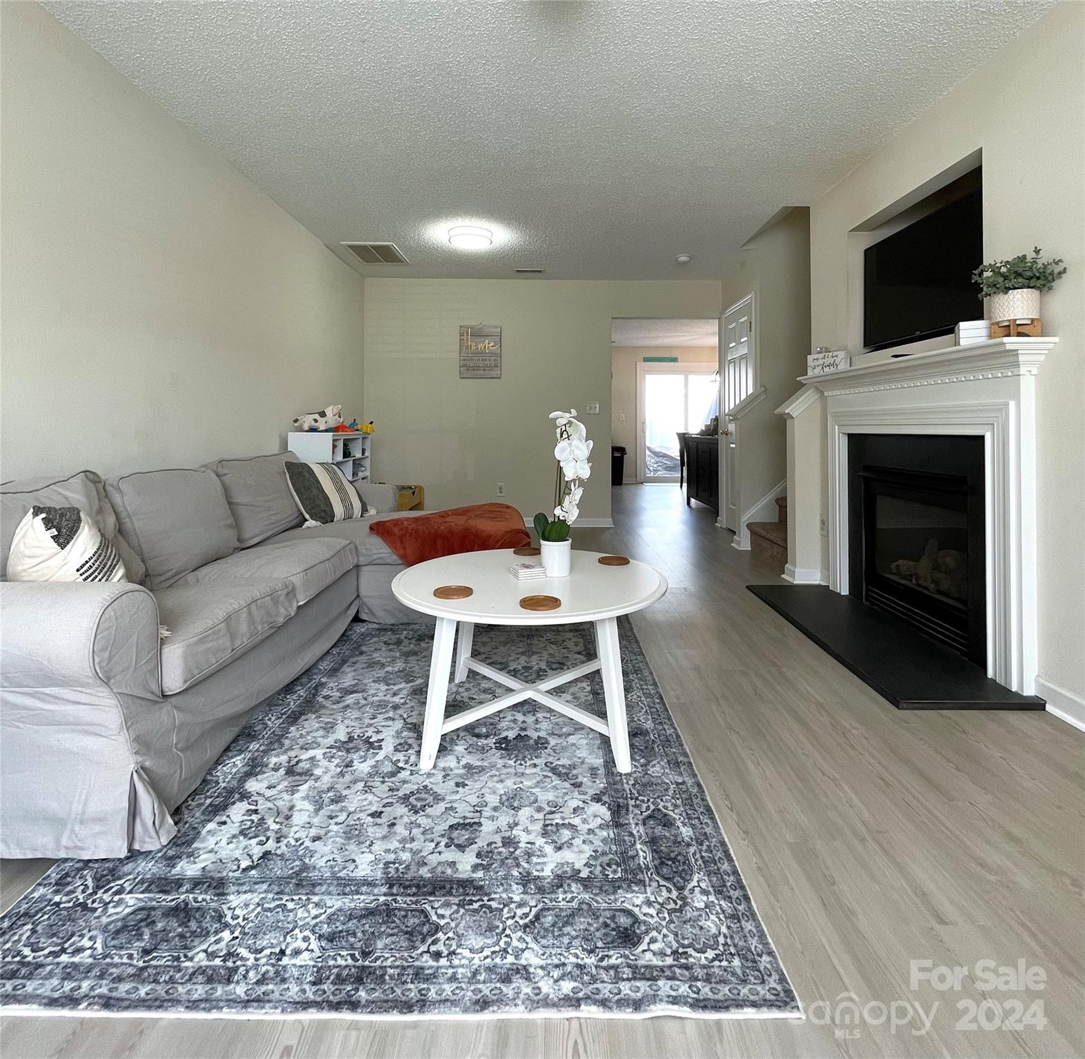 3216 Barons Court Road Charlotte, NC 28213 - Photo 7 of 29 a living room with furniture a flat screen tv and a fireplace