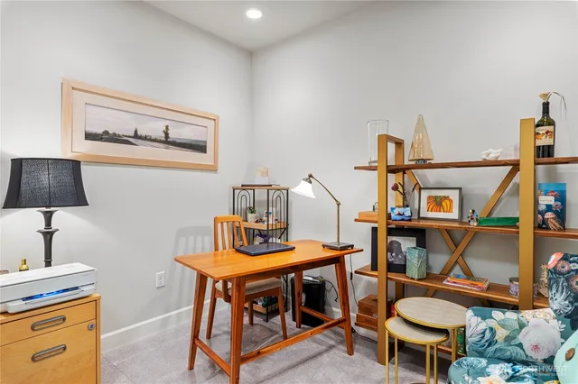 a bedroom with a bed and a lamp on dresser