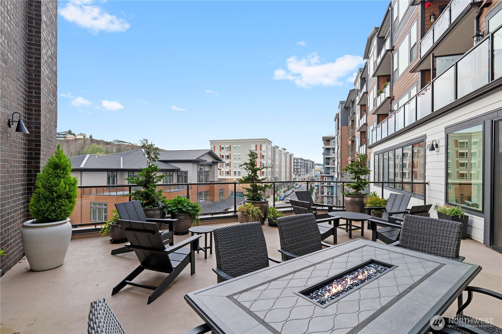 4907 Main Street, Unit 702 Tacoma, WA 98407 - Photo 31 of 33 a view of a rooftop deck with chairs and a potted plant