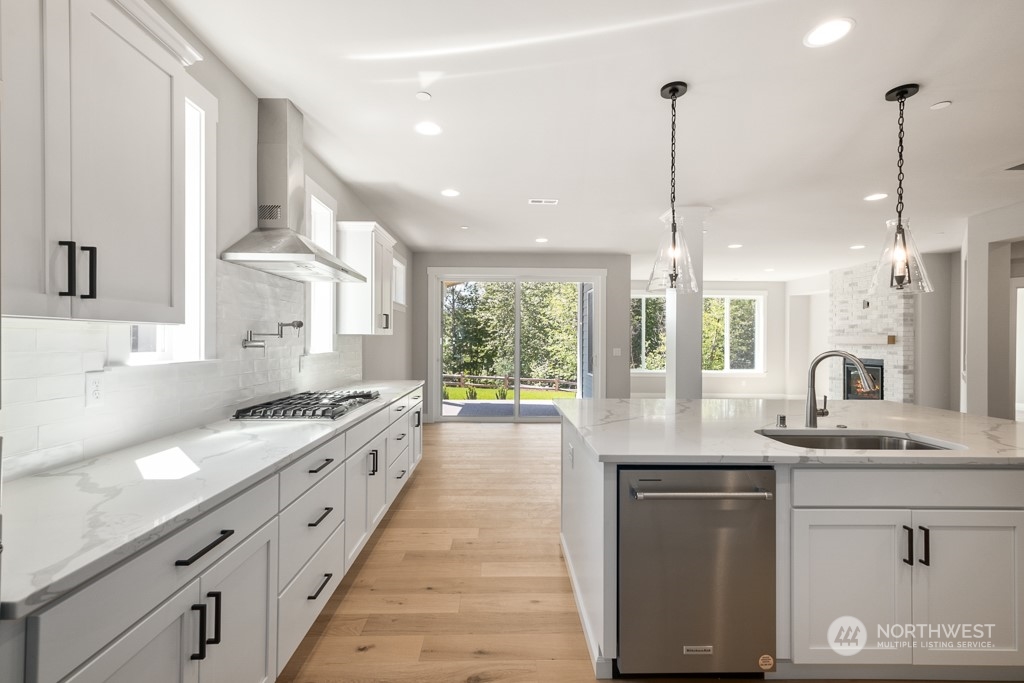 8713 Northeast 204th Street Bothell, WA 98011 - Photo 18 of 25 a kitchen with stainless steel appliances granite countertop a sink a stove and a wooden floors