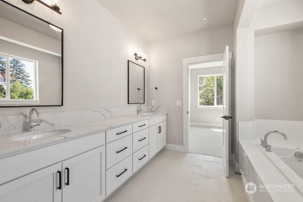8713 Northeast 204th Street Bothell, WA 98011 - Photo 25 of 25 a bathroom with double vanity sink a two mirror a window a bathtub and vanity