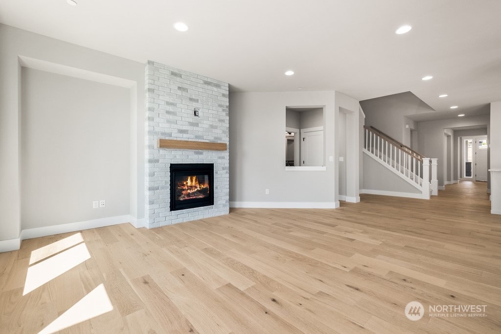 8713 Northeast 204th Street Bothell, WA 98011 - Photo 10 of 25 a view of an empty room with wooden floor fireplace and a window