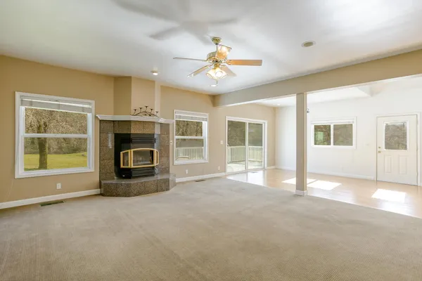 a view of an empty room with a fireplace and a window