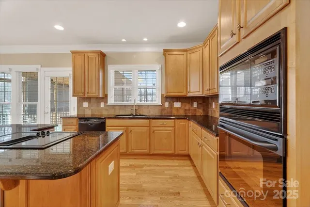 a kitchen with stainless steel appliances granite countertop a sink stove and cabinets