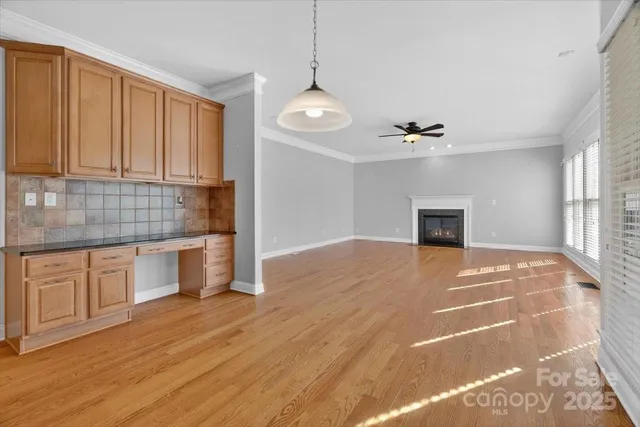 a view of empty room with kitchen and window