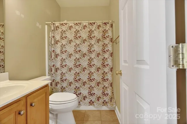 a bathroom with a toilet and a shower curtain