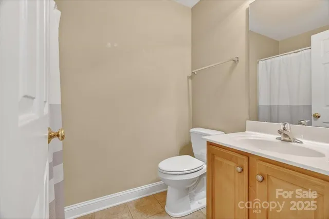 an empty room with chandelier fan and windows