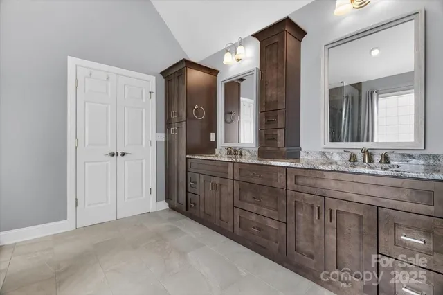a bathroom with a granite countertop sink and a mirror