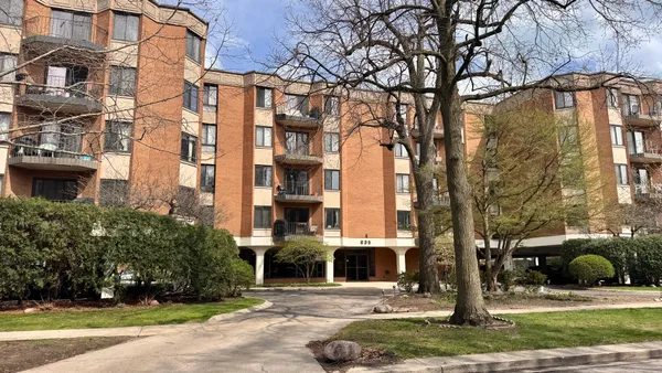 a view of a building with a yard and plants