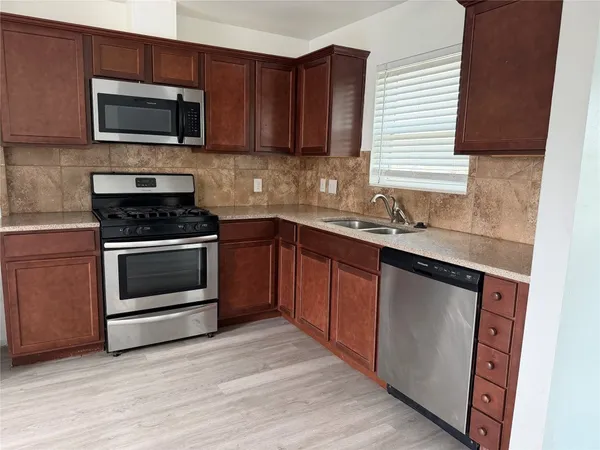 a kitchen with a sink stove and microwave