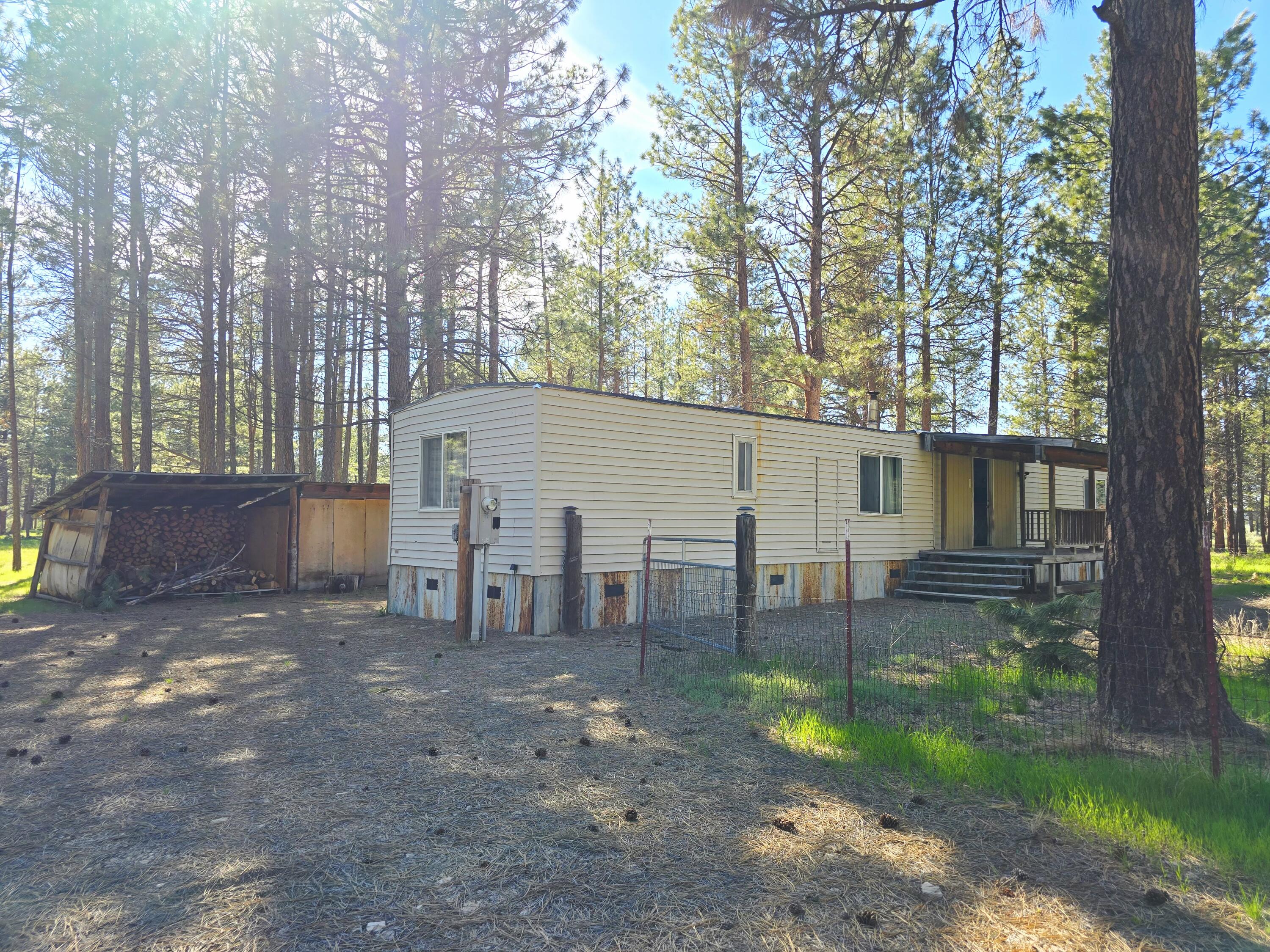34614 Sprague River Road Sprague River, OR 97639 - Photo 7 of 24 a view of a backyard with chairs and a large tree