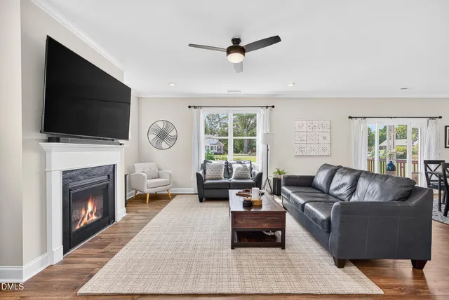 a living room with furniture a fireplace and a flat screen tv