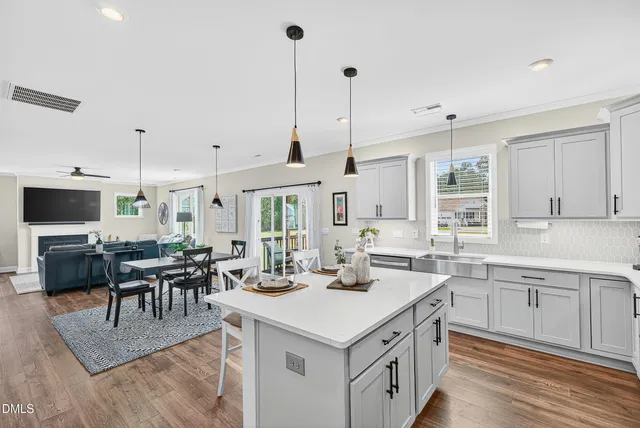 a kitchen with a sink stove and chairs