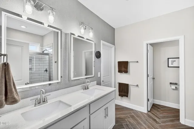 a bathroom with a sink double vanity granite and a mirror