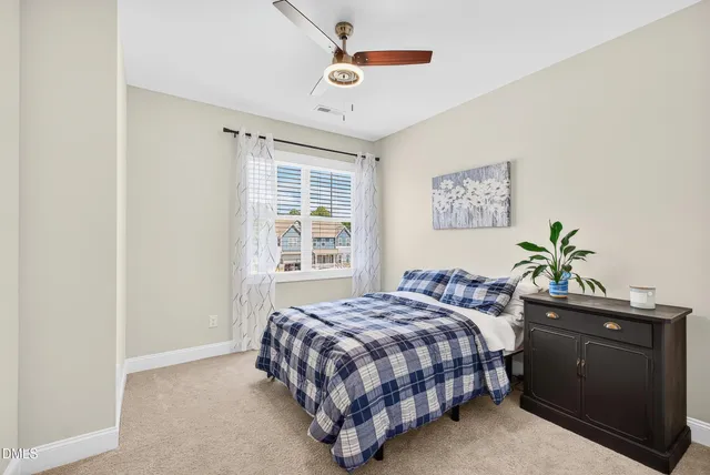 a bedroom with a bed a dresser and a window