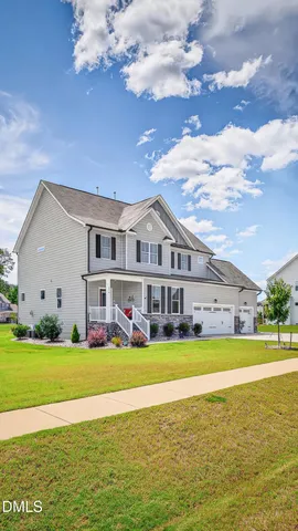 a view of a house with a big yard and large trees