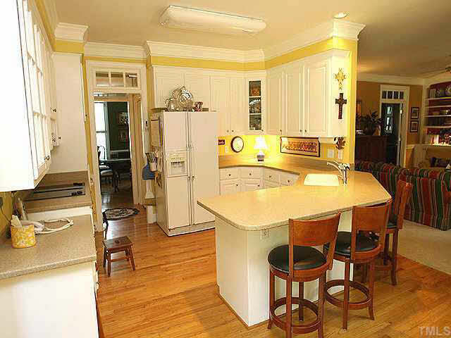 9113 Reedham Oaks Court Raleigh, NC 27615 - Photo 4 of 10 Light and bright kitchen with corian countertops and sink, plenty of 42 inch cabinets, smooth top down vent Jenair stove and huge prep and eat-in bar space.