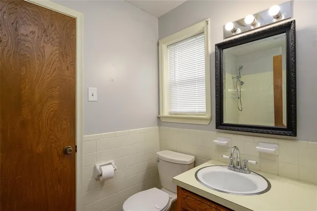 a bathroom with a toilet a sink and mirror