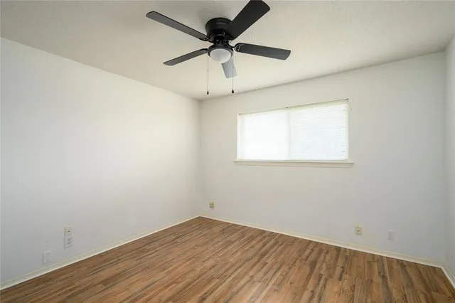 an empty room with a window and a ceiling fan