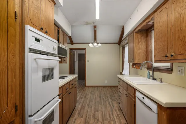 a kitchen with stainless steel appliances a sink cabinets and wooden floor