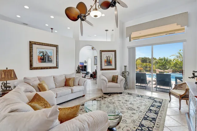 a living room with furniture kitchen view and a large window