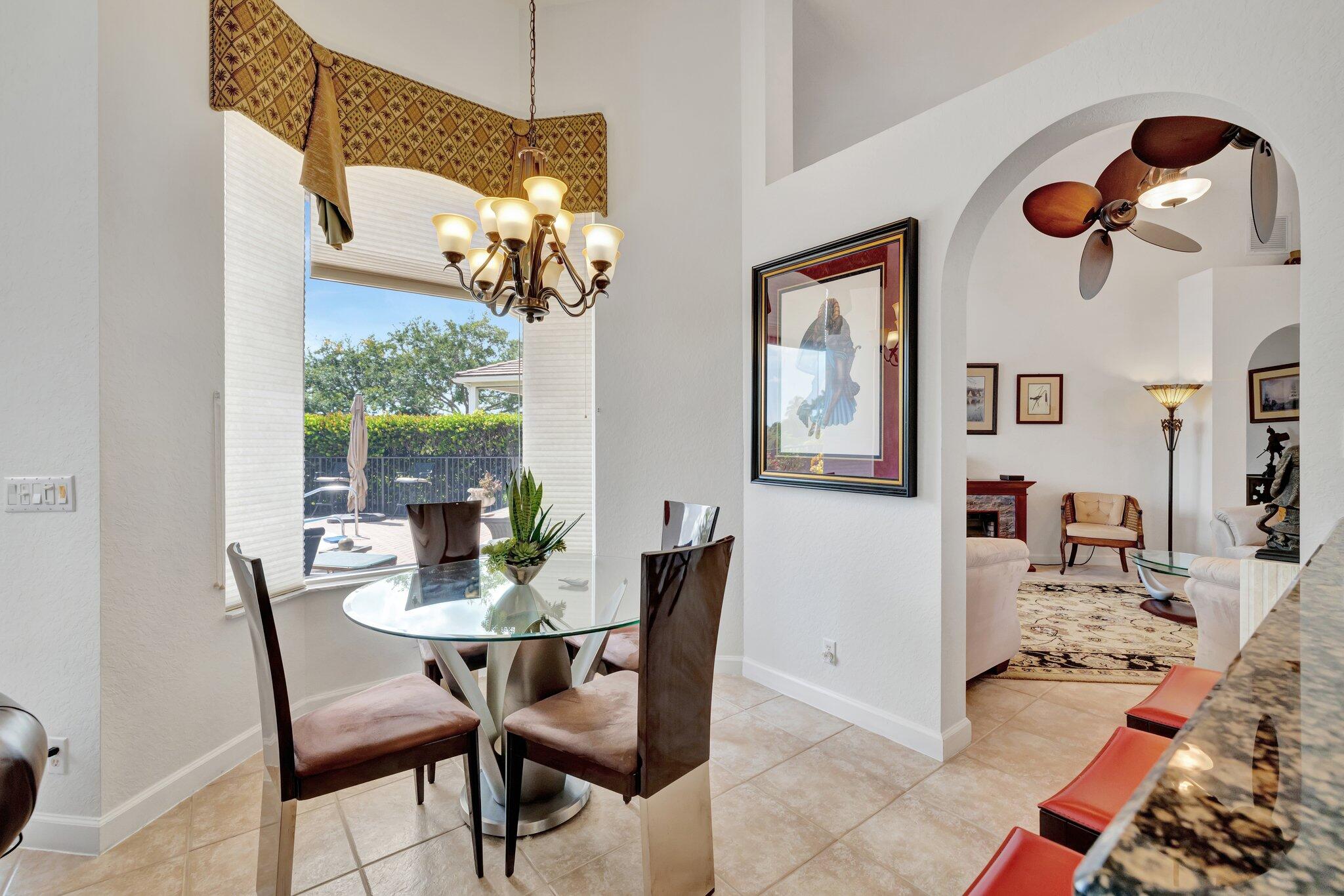 699 Southwest River Bend Circle Stuart, FL 34997 - Photo 17 of 78 a dining room with wooden floor a chandelier fan a wooden table and chairs
