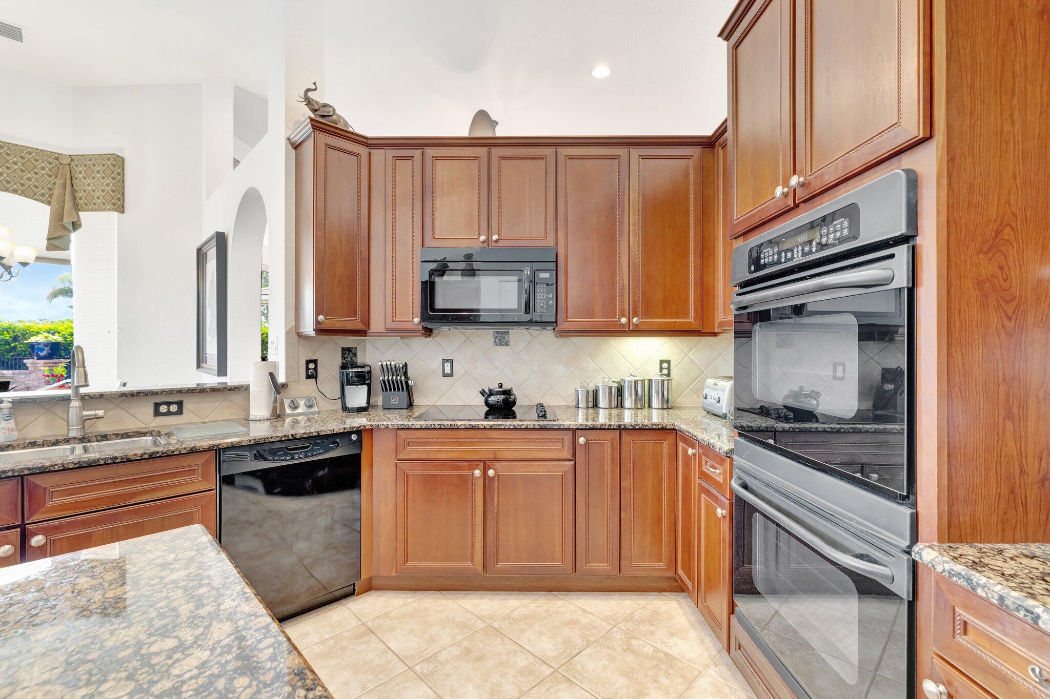 699 Southwest River Bend Circle Stuart, FL 34997 - Photo 18 of 78 a kitchen with stainless steel appliances granite countertop a sink stove and refrigerator