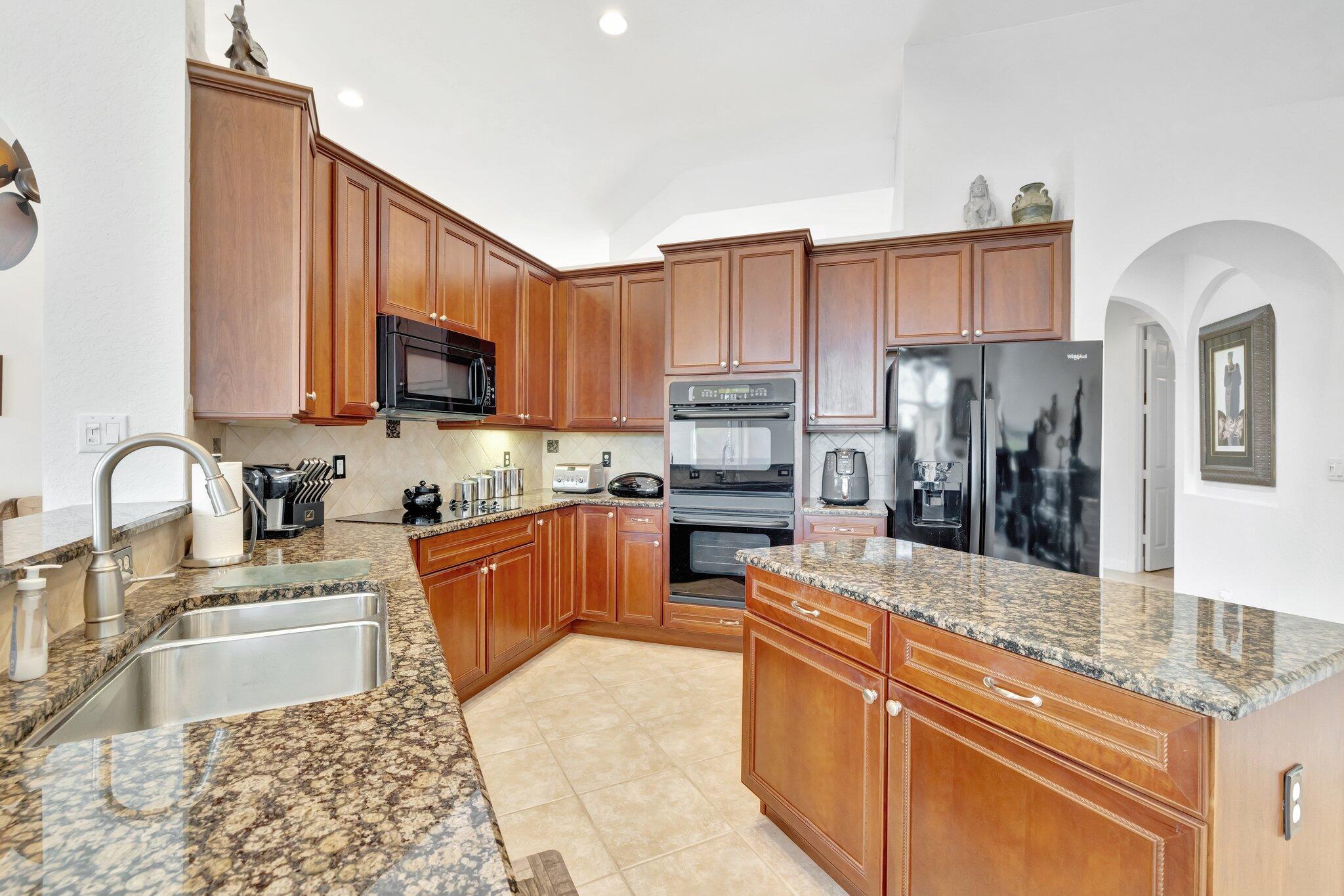 699 Southwest River Bend Circle Stuart, FL 34997 - Photo 19 of 78 a large kitchen with stainless steel appliances granite countertop a refrigerator a stove top oven a sink and dishwasher