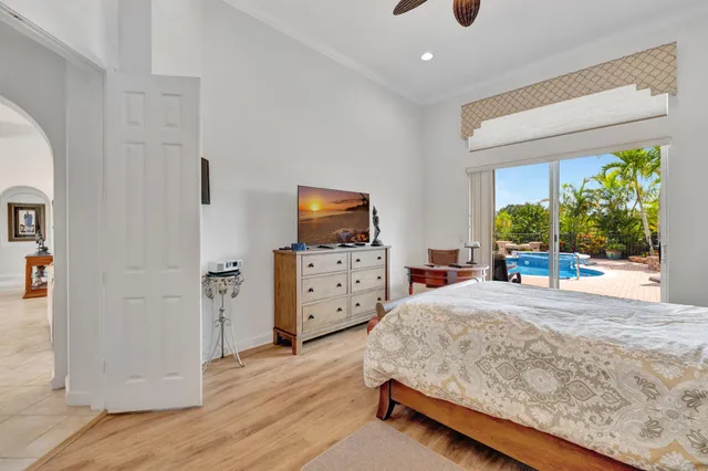 a bedroom with a bed and a flat tv screen on the dresser