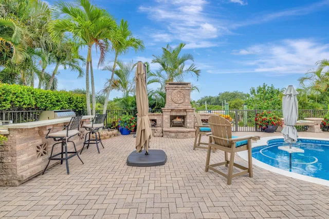 a view of a swimming pool with lawn chairs under an umbrella