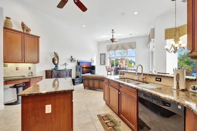 a kitchen with stainless steel appliances granite countertop a refrigerator a sink a stove and cabinets