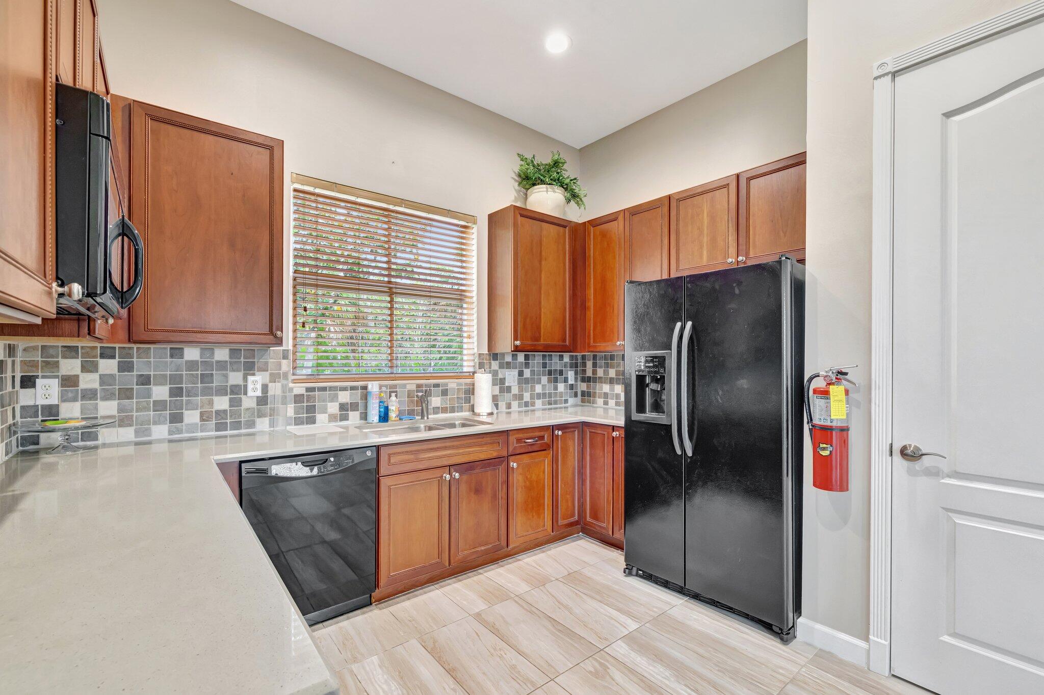 699 Southwest River Bend Circle Stuart, FL 34997 - Photo 58 of 78 a kitchen with stainless steel appliances granite countertop a refrigerator a sink a stove and cabinets