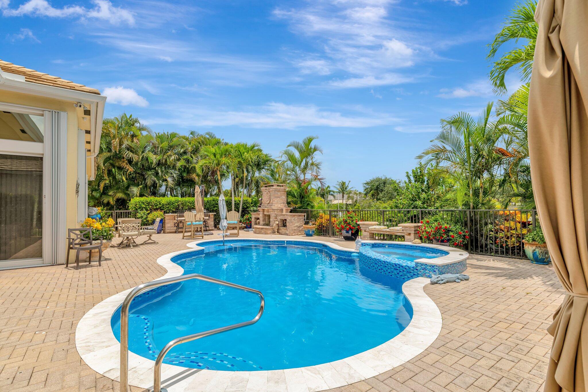 699 Southwest River Bend Circle Stuart, FL 34997 - Photo 7 of 78 a view of a swimming pool with lawn chairs under an umbrella