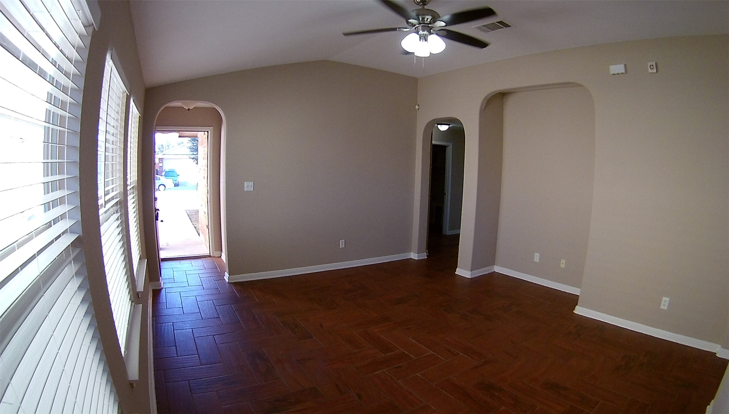 3304 Wickham Lane Austin, TX 78725 - Photo 11 of 13 Unfurnished room featuring lofted ceiling, ceiling fan, parquet flooring, and arched walkways