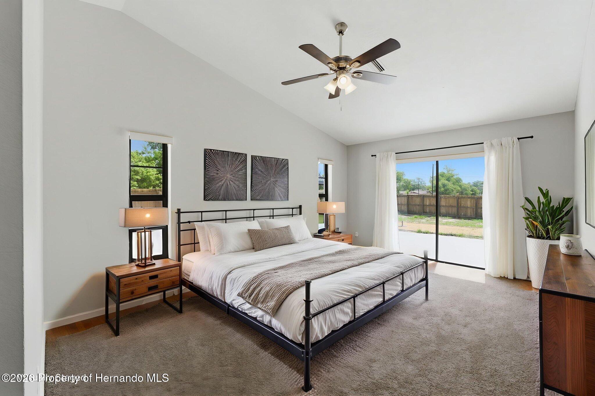 4966 Keysville Avenue Spring Hill, FL 34608 - Photo 25 of 50 a bedroom with a large bed and a chandelier
