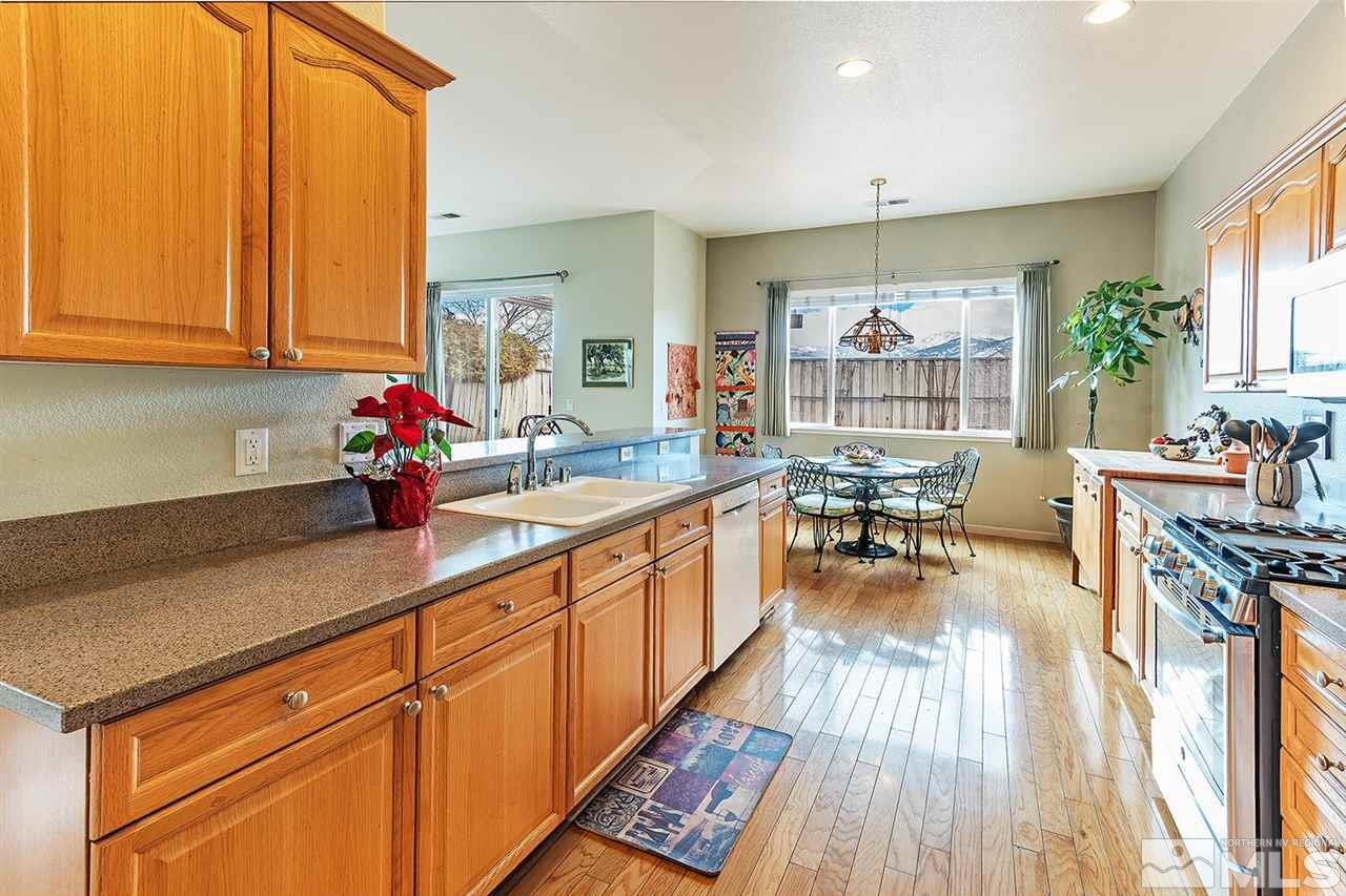 10535 Arbor Way Reno, NV 89521 - Photo 3 of 19 a kitchen with stainless steel appliances granite countertop sink stove and wooden cabinets