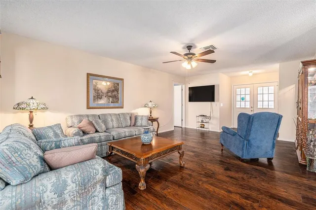 a living room with furniture and a flat screen tv with wooden floor