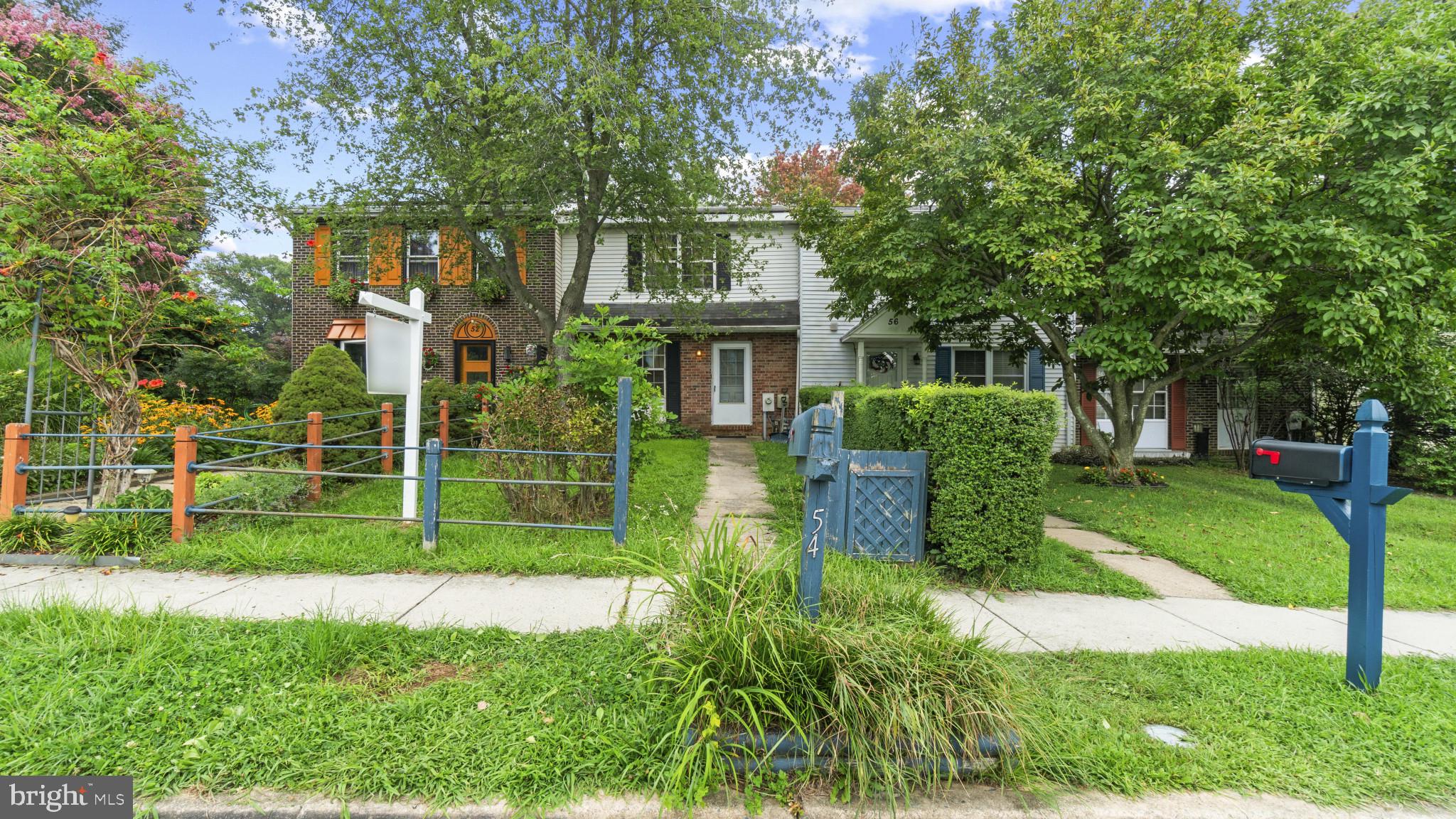 a view of house with a big yard and potted plants