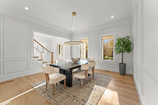 a view of a hallway with wooden floor and chandelier
